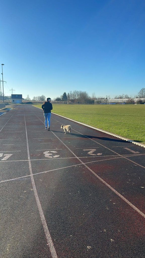 Ronja beim Laufen auf der Tartanbahn, begleitet von ihrer Hündin Wilma